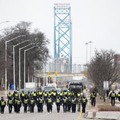 13日、カナダ東部オンタリオ州ウィンザーで、デモ隊の強制排除のため並んで歩く警察官ら（The　Canadian　Press提供・AP＝共同）