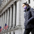 ニューヨーク証券取引所の前を歩く人＝18日（UPI＝共同）