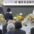 富山外国語専門学校で開かれた追悼の集いであいさつする在校生代表（奥）＝22日午前、富山市