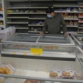 食料不足を懸念する住民が買いだめをする中、冷凍食品を探す男性＝5日、香港のスーパー（AP＝共同）