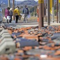 福島県相馬市で給水に並ぶ人たち。手前には瓦が崩落したままだった＝19日午前