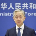 記者会見する中国外務省の汪文斌副報道局長＝21日、北京（共同）