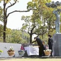 私立高知学芸高で営まれた上海列車事故の慰霊式で献花する遺族ら＝24日午前、高知市