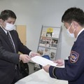 山口県美祢市消防本部に公務災害の認定を求める申請書を提出する、竹田勇二さんの両親の代理人弁護士（左）＝26日午前