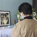 小尻知博記者の遺影に手を合わせる女性＝3日、兵庫県西宮市の朝日新聞阪神支局