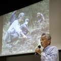 木村汐凪さんの捜索時の写真を背に講演する具志堅隆松さん＝4日午後、福島県大熊町