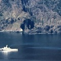 北海道・知床半島沖で捜索する海上保安庁の巡視船。右奥はカシュニの滝＝6日午後1時54分（共同通信社ヘリから）