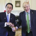 5日、福島産のポップコーンを手にするジョンソン英首相（右）と岸田首相＝ロンドン（英首相官邸提供・共同）
