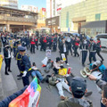 市民団体のデモを妨害しようとJR吉祥寺駅前の車道に寝そべる人たち＝2021年12月4日、東京都武蔵野市