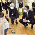 子育て交流サロンを視察する岸田首相（右から2人目）。右端は後藤厚労相＝12日午前、東京都中央区（代表撮影）