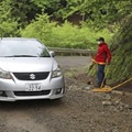 山梨県道志村の山中で、規制線の外に出る車両＝17日午後