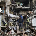 ロシア軍の攻撃で破壊された集合住宅での救助活動＝18日、ウクライナ・ドネツク州（AP＝共同）