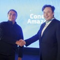 米電気自動車テスラのイーロン・マスクCEO（右）と握手するブラジルのボルソナロ大統領＝20日、ブラジル・ポルトフェリス（ブラジル通信省提供、AP＝共同）