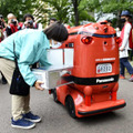 商品を積み込まれる自動配送ロボット＝26日、茨城県つくば市