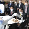 ロボットが配膳するレストランを視察する、タイのプラユット首相（手前）＝27日午後、東京都大田区の羽田イノベーションシティ