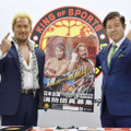 消防団員募集のポスターを手にする新日本プロレスの真壁刀義選手（左）と田畑裕明総務副大臣＝1日午後、東京都中野区