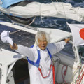 ヨットで単独無寄港の太平洋横断に成功し、帽子を振る堀江謙一さん＝4日午後2時52分、大阪湾（共同通信社ヘリから）