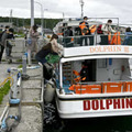 運航を開始した小型観光船に乗り込む乗客ら＝16日午前、北海道斜里町