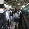 東北新幹線（右）が停車し、白石蔵王駅で後続の列車に乗り換える人たち＝23日午前11時51分、宮城県白石市