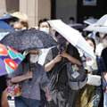 猛烈な暑さの中、日傘を差して歩く人たち＝26日午後、東京・銀座