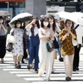 猛暑の中、東京・表参道を歩く人たち＝30日午後