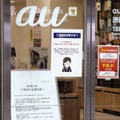 KDDI（au）の大規模通信障害について謝罪の看板を掲げるJR渋谷駅近くのauショップ＝3日午後、東京都渋谷区