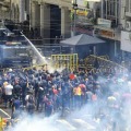9日、スリランカ・コロンボで、放水砲や催涙ガスを使いデモ隊の鎮圧に当たる警察（AP＝共同）