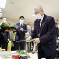 船内の献花台に花を供える色丹島出身の得能宏さん＝23日午前、北海道根室半島沖の洋上