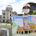 原爆ドームの絵を描いた栗原莉奈さん＝23日午後、広島市の平和記念公園