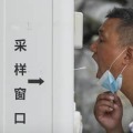 北京で新型コロナの検査を受ける男性＝19日（AP＝共同）