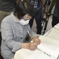 坪井直さんの名前を原爆死没者名簿に記帳する被爆者で元広島市職員の中本信子さん＝29日午後、広島市