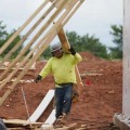 住宅建設現場で板を運ぶ作業員＝2021年6月、米オクラホマ州（AP＝共同）