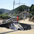 道路の陥没部分から引き上げられる車＝8日、福井県南越前町