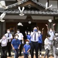 米兵と地元戦没者の慰霊祭で、鳩を飛ばす参列者＝15日正午ごろ、三重県名張市