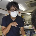 薬局で特殊詐欺の啓発チラシを入れた薬袋を手渡す船多大さん＝22日午前、大阪府河内長野市