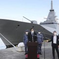 視察を終え、記者の質問に答える浜田防衛相（中央）。奥は新型護衛艦「もがみ」＝5日午後、神奈川県横須賀市の海上自衛隊横須賀基地（代表撮影）