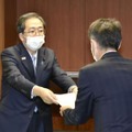 日野自動車の小木曽聡社長（右）に是正命令書を手渡す斉藤国交相＝9日午後、国交省