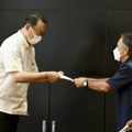 岡田沖縄北方相（左）に要望書を手渡す、沖縄県の玉城デニー知事＝14日午後、沖縄県庁