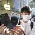 米アップル「iPhone」の新型「14」シリーズを購入した男性＝16日朝、東京・表参道