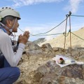 御嶽山の王滝頂上で、妻の玲子さんが亡くなった「八丁ダルミ」に向かって手を合わせる丹羽隆文さん＝26日午前