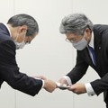 総務省総合通信基盤局の竹村晃一局長（左）から行政指導の文書を受け取るNTT西日本の森林正彰社長＝30日午前、総務省