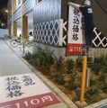 価格が表示された垂れ幕を交換するくら寿司朝潮橋店の従業員＝9月30日夜、大阪市港区