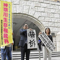 生活保護費減額処分の取り消しなどを求めた訴訟の判決後、「勝訴」と書かれた紙を掲げる弁護士ら＝19日午前、横浜地裁前
