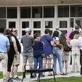 8月、米中間選挙に向けた予備選の投票所前に列をつくって並ぶ人たち＝米ワイオミング州シャイアン（共同）