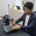新商品のミシンで実演するアックスヤマザキの山崎一史社長＝10月、大阪市
