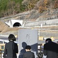 笹子トンネルの天井板崩落事故から10年となり、慰霊碑に献花し手を合わせる遺族。左奥は中央自動車道笹子トンネル上り線＝2日午前、山梨県大月市（代表撮影）