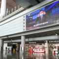 閑散とする北京首都国際空港の到着ロビー。大型モニターにはマスク着用を呼び掛ける映像が流れていた＝12日（共同）