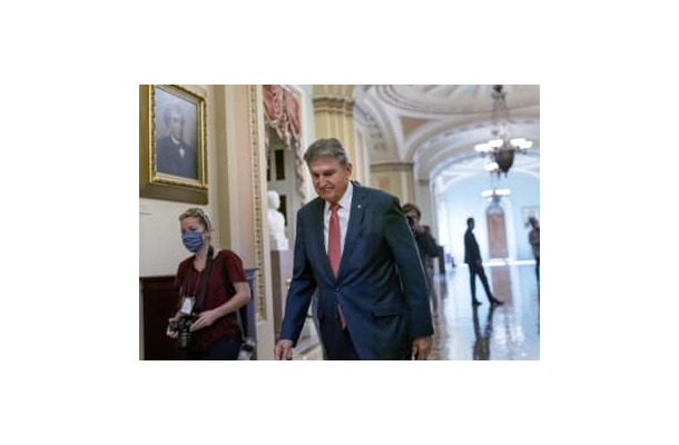 米議会内を歩く民主党のマンチン上院議員＝17日、ワシントン（AP＝共同）