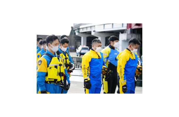 行方不明者の捜索前に、黙とうする静岡県警の警察官＝3日午前9時56分、静岡県熱海市