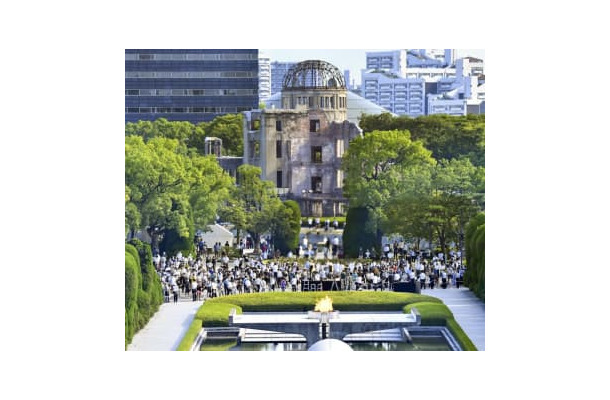昨年8月6日、広島市の平和記念公園で黙とうする人たち。後方は原爆ドーム